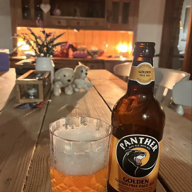 bottle of Panther Golden, partially poured in a glass, on a table