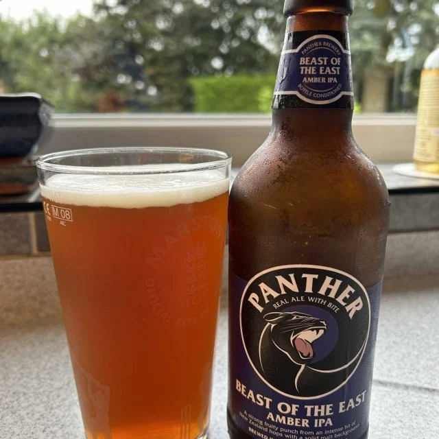 Panther Brewery Beast of the east poured out in to glass next to bottle