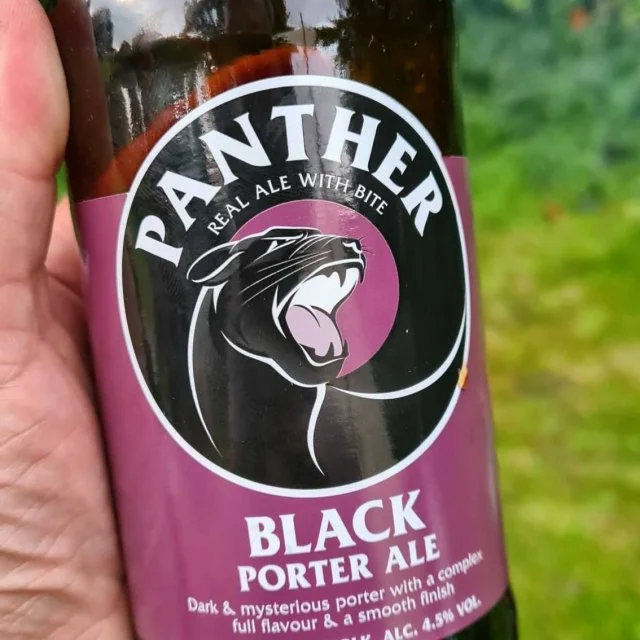 Panther brewery black bottle in customer hand