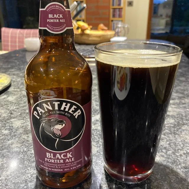 Panther brewery black poured in glass beside bottle